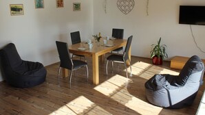 A dining area with a wooden table, black chairs, and bean bags. - Forgetful the big one (Titisee-Neustadt)