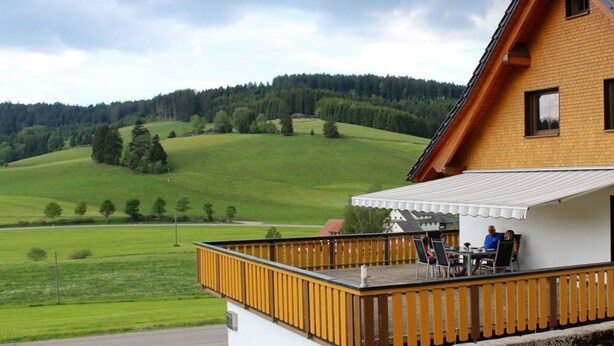 A house with a wooden balcony overlooking a green landscape. - Forgetful the big one (Titisee-Neustadt)