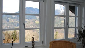 A room with large windows offering a mountain view.