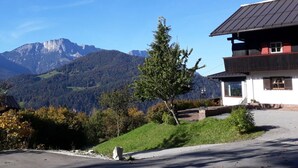 A mountain view with a building featuring a sloped roof and a small porch.