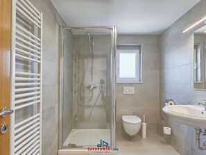 A modern bathroom with a glass-enclosed shower, a toilet, and a sink. - met Wellness Studio D (Pula)
