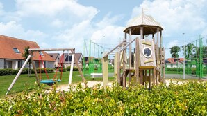 Ein Spielplatz mit Schaukeln und einer Kletterkonstruktion.