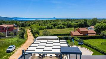 A residential property with a patio area, a car parked outside, and a view of the surrounding countryside.