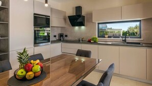 A modern kitchen with a built-in oven, microwave, and a large window. - Villa Bella Vita (Barban)