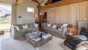 Un salón amplio con dos sofás, una mesa de centro y una chimenea.