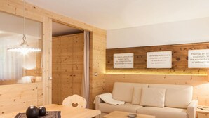 A cozy room with a wooden dining table, a sofa, and a wall with inspirational quotes. - Apartment Carpe Diem (Merano)