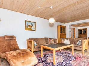 A living room with a wooden ceiling, a sofa set, a coffee table, and a patterned rug. - 9 Person Holiday Home in Thyholm (Thyholm)
