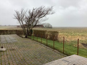 A paved outdoor area with a metal fence and a tree. - 9 Person Holiday Home in Thyholm (Thyholm)