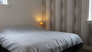 A bedroom with a bed, a nightstand, and a lamp. - Holiday Home Leuk Comfortable Vacation Home (Callantsoog)