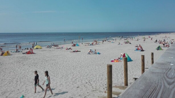 A beach with people walking and tents set up. - Holiday Home Leuk Comfortable Vacation Home (Callantsoog)