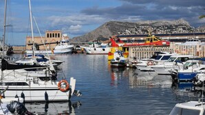 A marina with various boats docked, a lifebuoy, and a mountainous backdrop. - Villa Miraflores Comfortable Holiday Residence (Teulada)