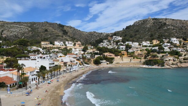 A coastal town with a sandy beach, buildings along the shore, and hills in the background. - Villa Miraflores Comfortable Holiday Residence (Teulada)