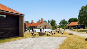 Ein Innenhof mit Picknicktischen, einem Spielplatz und einem Gebäude mit rotem Ziegeldach.