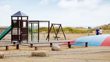 A playground with a slide, swings, and a climbing structure.