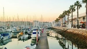 A marina with numerous boats docked along a wooden walkway. - Apartment Marina Sky (Lagos)