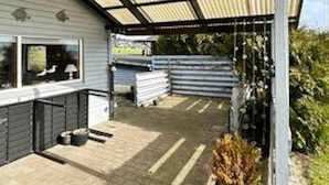A covered outdoor area with a metal roof, a paved floor, and a small plant. - 8 Person Holiday Home in Aabenraa (Aabenraa)
