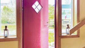 A red door with a small window, a wooden staircase, and two lanterns on the windowsill. - 4 Star Holiday Home in Onsala (Gottskar)