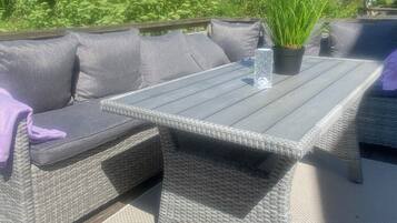 A wicker outdoor seating area with cushions and a table.