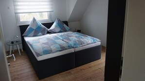 A bedroom with a bed, a small table, and a window with blinds. - Elisabeth on the Loreley (Sankt Goar)