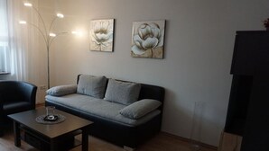 A modern living room with a grey sofa, a coffee table, and two floral paintings on the wall. - Elisabeth on the Loreley (Sankt Goar)