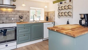 A modern kitchen with a built-in oven, a dishwasher, and a coffee maker.