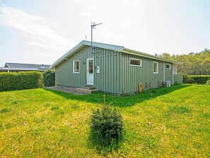 A single-story metal building with a flat roof, a front door, and a small porch. - 5 Person Holiday Home in Juelsminde (Horsens)