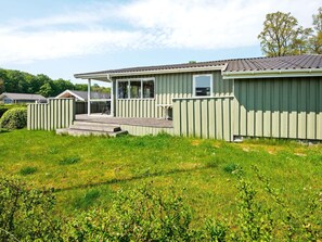 A single-story building with a covered patio area, a fenced yard, and a clear sky. - 5 Person Holiday Home in Juelsminde (Horsens)