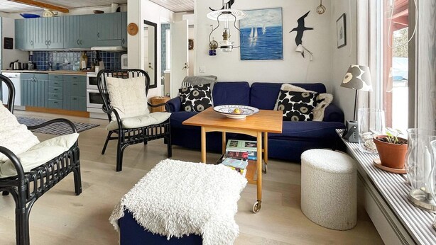 A cozy living room with a sofa, chairs, a coffee table, and a window with a view. - 6 Person Holiday Home in Blido (Blidö)