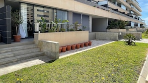 A modern multi-story building with balconies, a well-maintained lawn, and potted plants. - Belvilla by OYO Mirador Playa Serena (Roquetas de Mar)