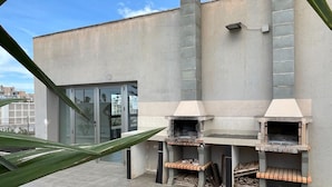 A modern outdoor kitchen area with two built-in wood-fired ovens, a glass door entrance, and a tiled patio. - Belvilla by OYO Mirador Playa Serena (Roquetas de Mar)
