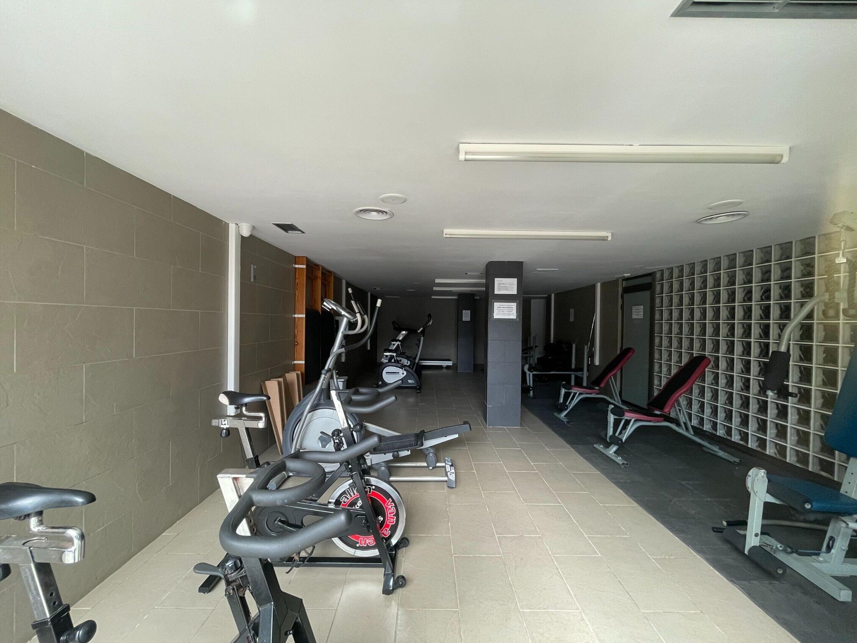 A gym with stationary bikes, treadmills, and weight machines.