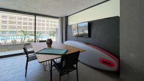 A modern living room with a dining table, chairs, a sofa, and a TV mounted on the wall. - Belvilla by OYO Mirador Playa Serena (Roquetas de Mar)