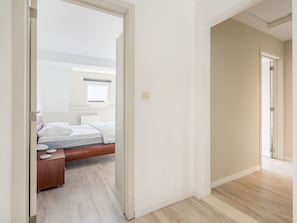 A bedroom with a bed, bedside table, and a window. - Bright Apartment in the City Center (Blankenberge)