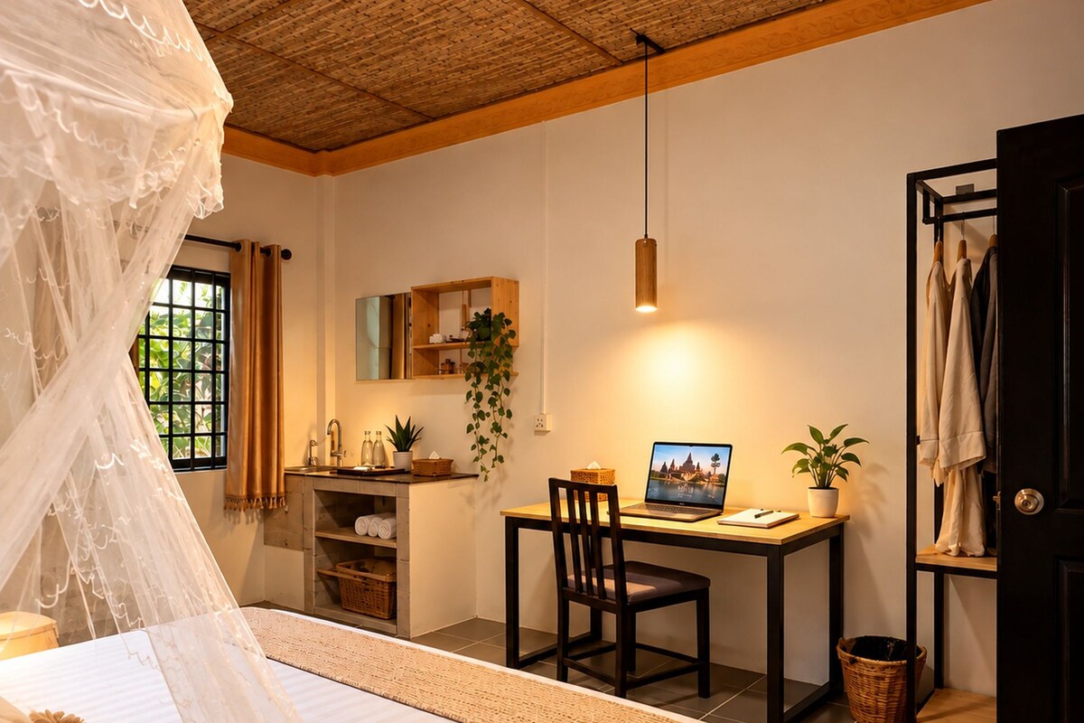 A bedroom with a bed, a desk, and a computer.