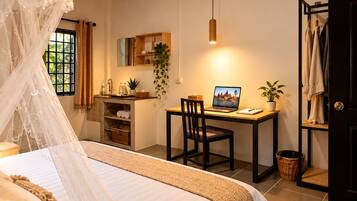 A bedroom with a bed, a desk, and a computer.