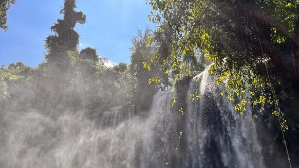 A waterfall in a forested area with clear water flowing over rocks. - Siem Reap Homesteading Garden Retreat (Siem Reap)