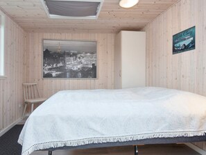 A room with a bed, a chair, a large framed picture of a cityscape, and a poster on the wall. - 7 Person Holiday Home in Juelsminde (Horsens)