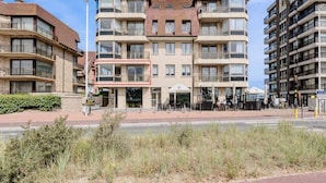 Ett hotell med flera våningar, en central innergård, en uteservering och utsikt över havet.