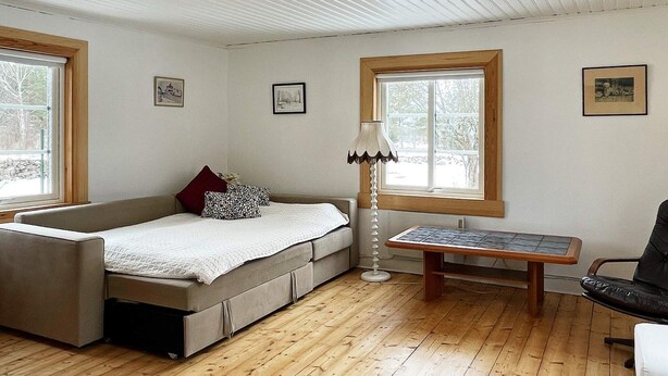 Ein Zimmer mit einem Bett, einem Tisch, einem Stuhl und einer Lampe.