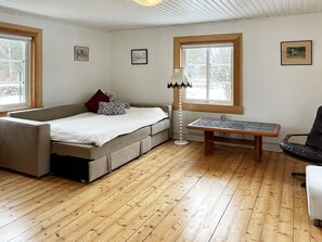 Une pièce comprenant un lit, une table, une chaise et une lampe.