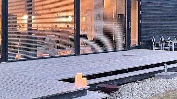 En modern byggnad med stora glasfönster och en träveranda.