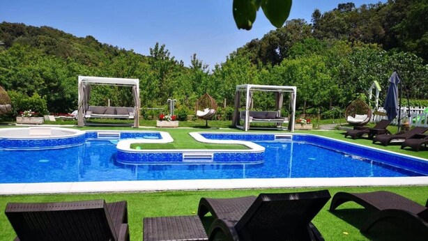 A swimming pool with two gazebos, lounge chairs, and a grassy area. - Apartments Villa Subic - One Bedroom Apartment With Balcony A1 (Rab)