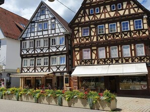 Un bâtiment traditionnel à colombages, doté de nombreuses fenêtres et d'une devanture de magasin.