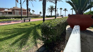 A paved walkway lined with palm trees and a large planter. - Belvilla by OYO Casa Manuela (Roquetas de Mar)