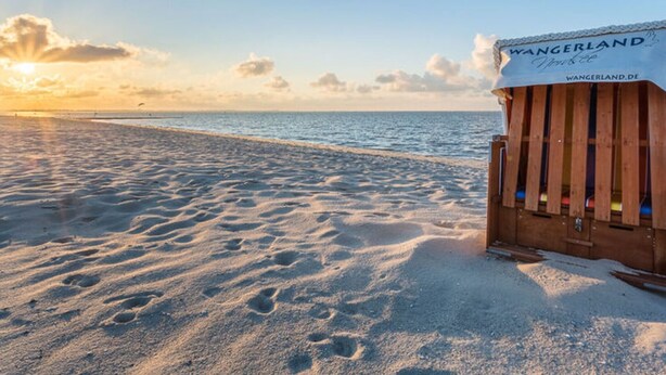 A wooden beach hut with a sign reading "WANGERLAND" and "WANGERLAND.DE". - Holiday Home Christmann (Wangerland)