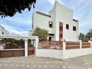 A modern two-story building with a white facade and wooden accents.