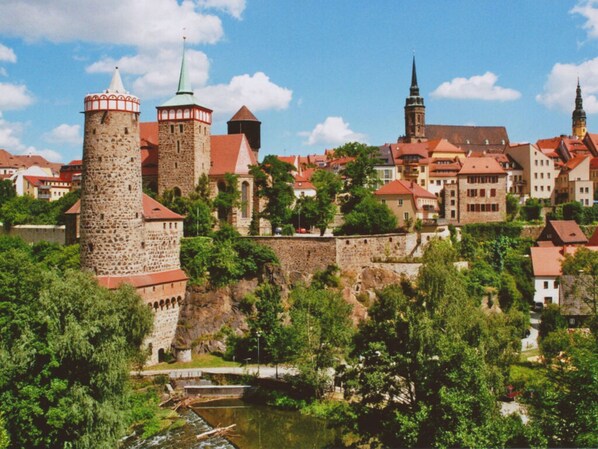 A historic town with a prominent stone tower and a church with a tall spire. - Holiday Home Seehutte (Malschwitz)