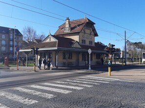 A train station with a classic architectural style, featuring a prominent clock tower and a covered waiting area.