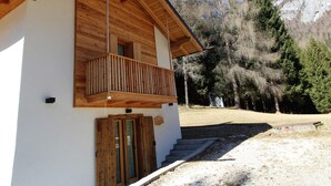 A wooden cabin with a balcony, a door, and a sign indicating a restaurant. - Belvilla by OYO Pleasant Holiday Home With Garden (Lozzo di Cadore)