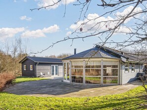 A house with a covered patio, a separate wooden structure, and a lawn. - 4 Star Holiday Home in Ansager (Ansager)